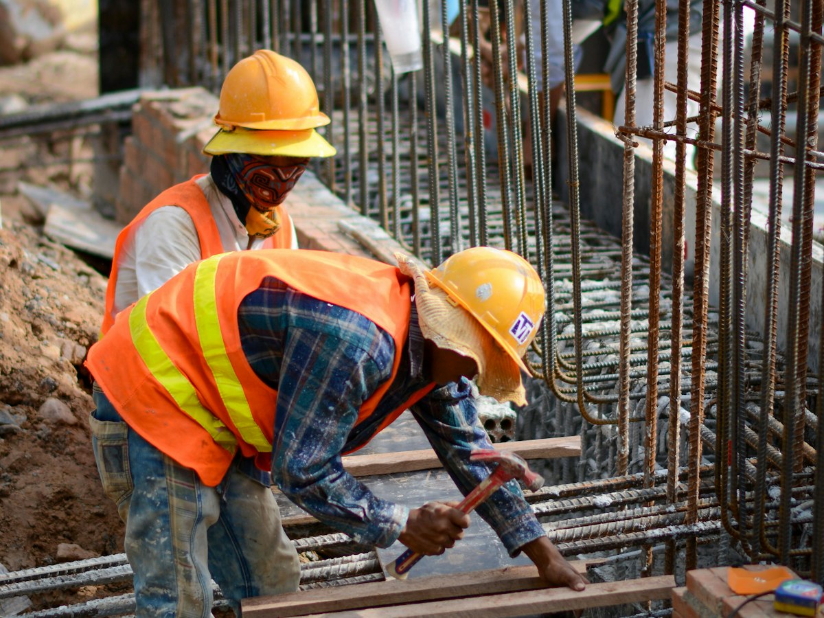Two contractors in hard hats working on one task on site