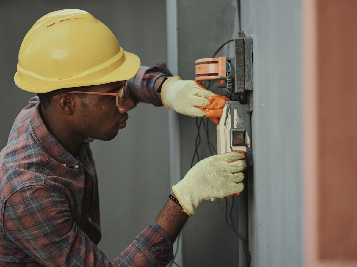 Electrician testing a wall-mounted distribution panel
