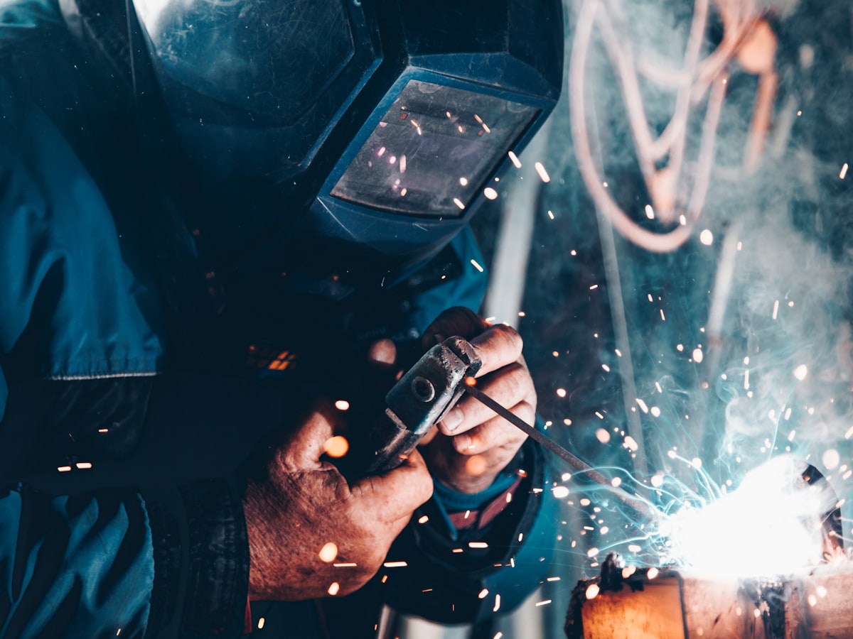 Welder cutting steel with sparks in a workshop