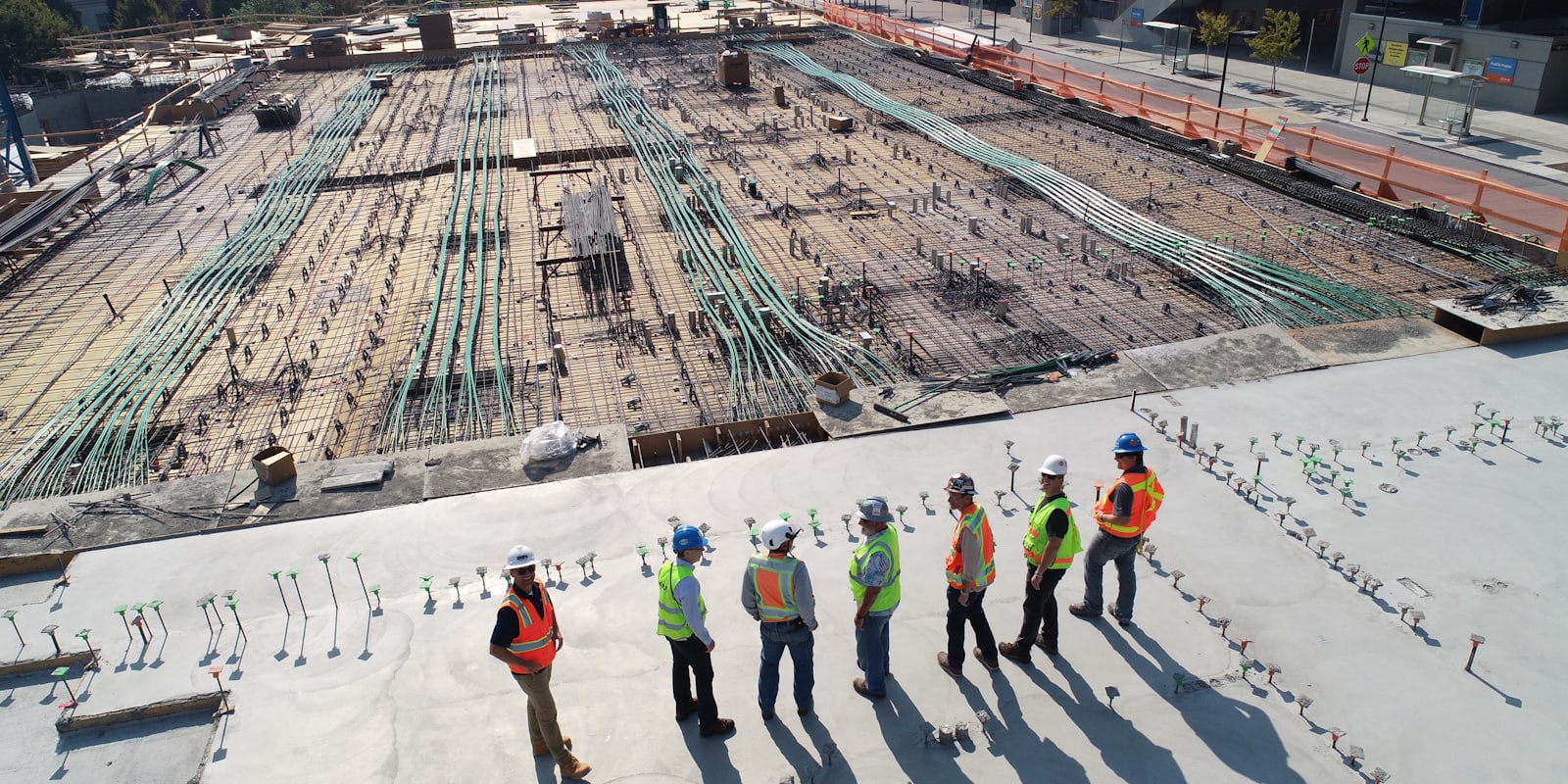 Construction crew working across a concrete slab, seen from above